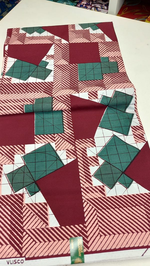 A red and green quilt with some white squares