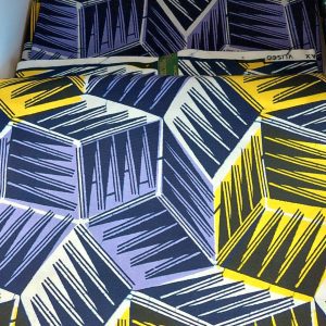 A close up of the fabric with yellow and blue cubes