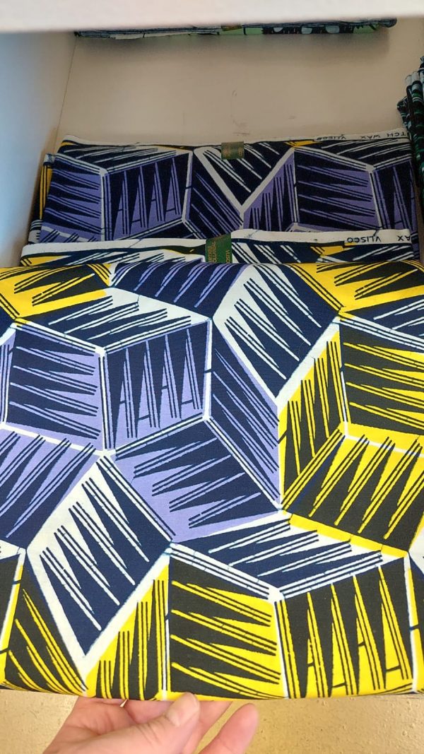 A close up of the fabric with yellow and blue cubes