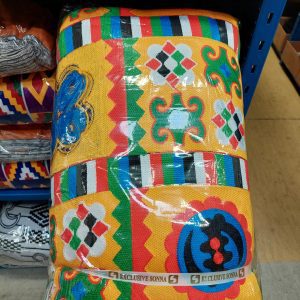 A colorful blanket sitting on top of a shelf.