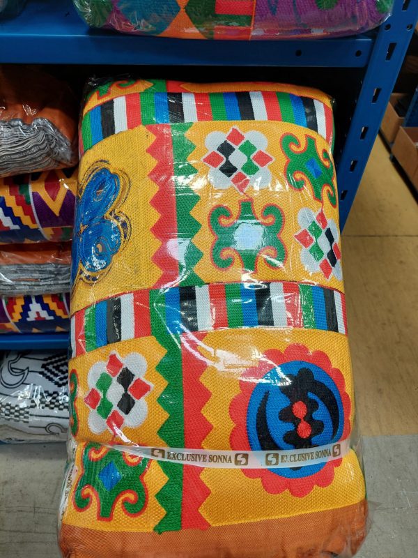 A colorful blanket sitting on top of a shelf.